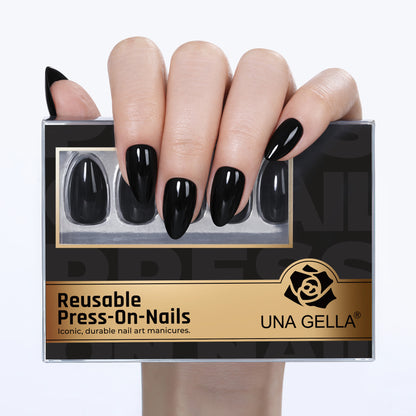 Black almond-shaped press-on nail tips by UNA GELLA, reusable gel false nails, 16 sizes included in a 32-piece set.