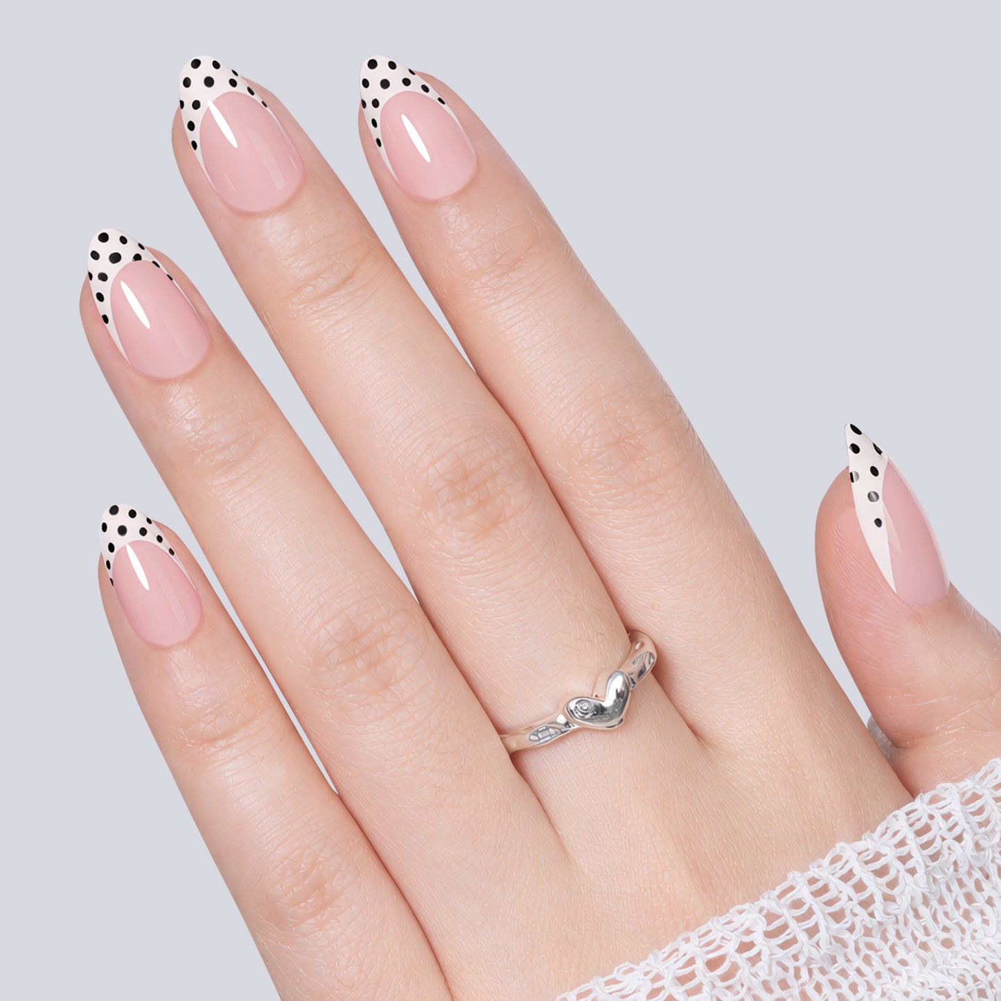 Set of 32 UNA GELLA polka dot French almond-shaped press-on nails with black polka dots on soft gel tips.