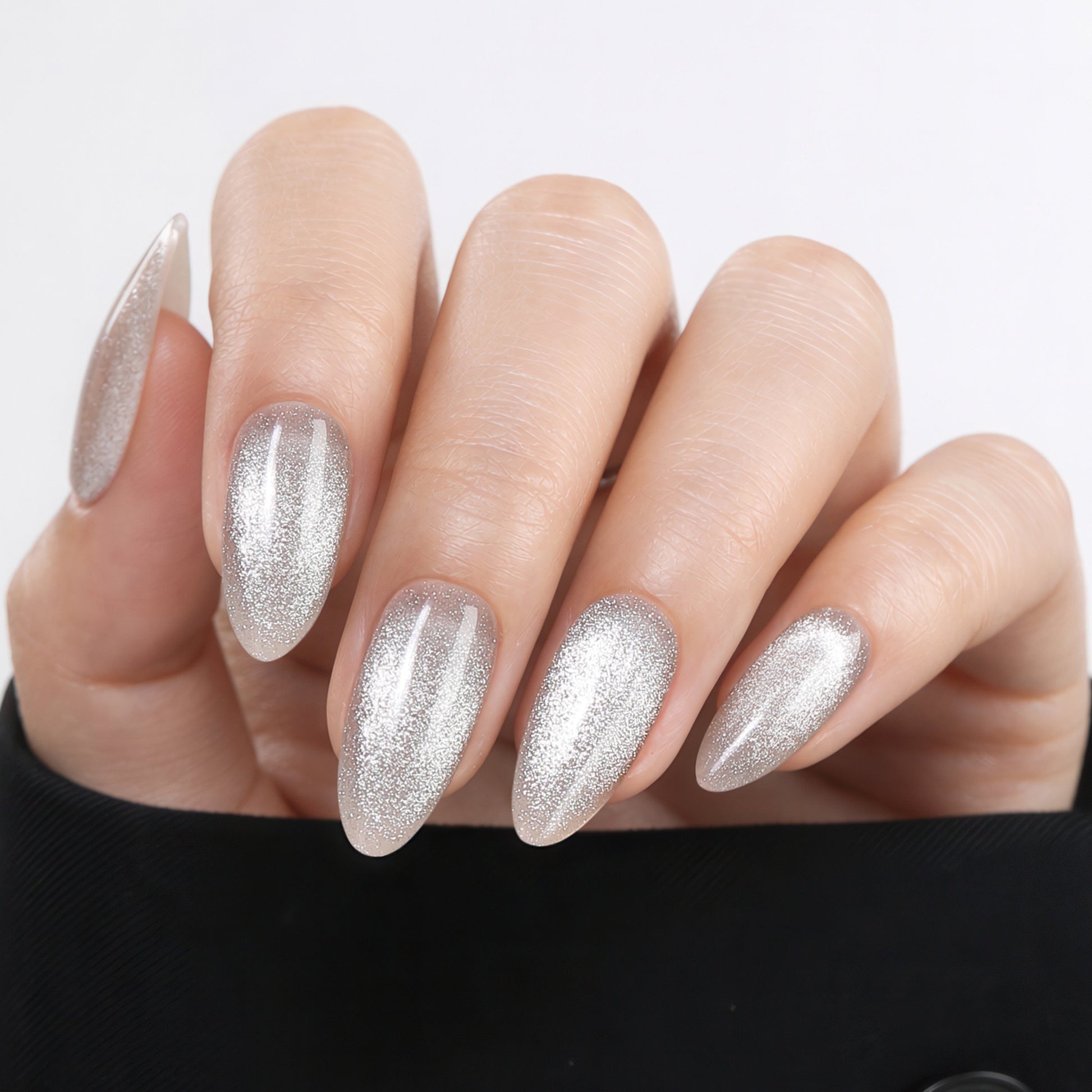 Silver cat eye almond-shaped press-on nails by UNA GELLA, 32-piece set with 16 sizes, reusable soft gel nail tips for DIY manicure.